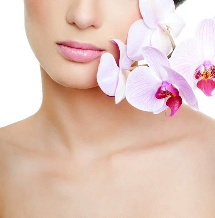 Dekollet Behandlung Dortmund - Ausschnitt eines weiblichen Gesichts mit Lippen und Dekollet, eine Orchidee an der linken Gesichtsseite